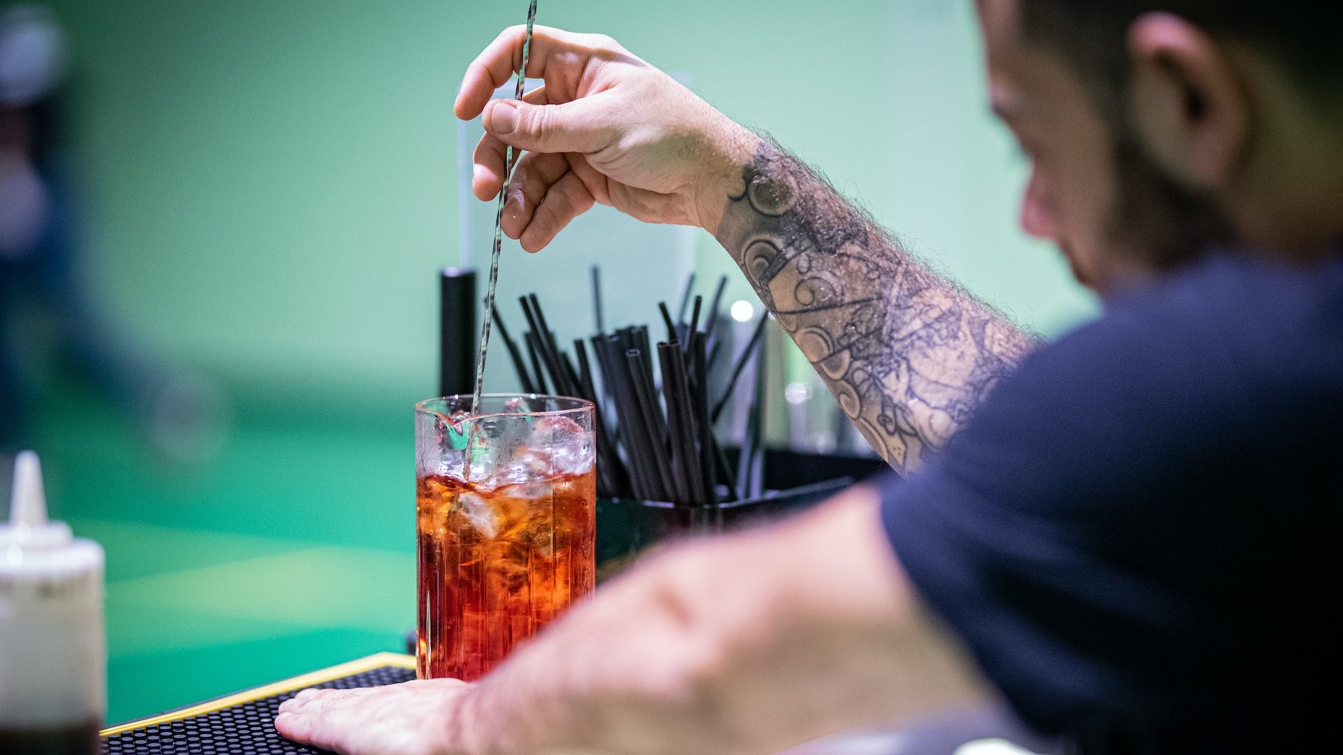 Barman servant un cocktail long island ice tea dans un verre